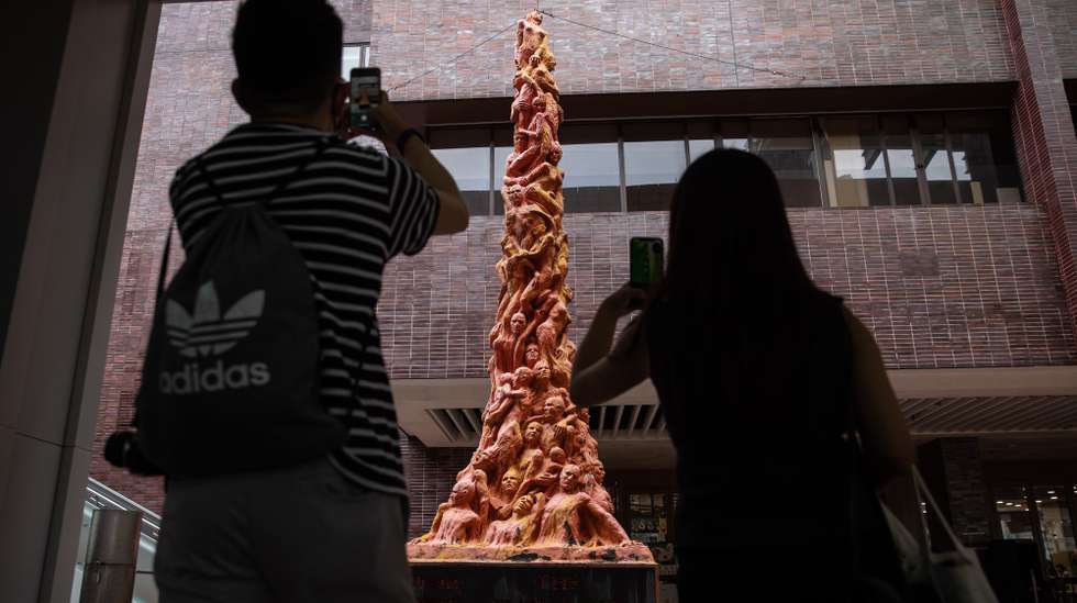 epa09516155 Visitors take photographs of the 'Pillar of Shame,' a statue depicting torn and twisted bodies by Danish artist Jens Galschiot to commemorate the victims of the 1989 Beijing Tiananmen Square crackdown, displayed at the University of Hong Kong, in Hong Kong, China, 10 October 2021. The university has informed the defunct Hong Kong Alliance in Support of Patriotic Democratic Movements of China, which was disbanded in August 2021 and to which the statue was originally donated to decades ago, that it has until 5pm on 13 October 2021, to remove the statue or else it would be deemed as 'abandoned.' The eight-metre-high 'Pillar of Shame' has been housed on the university's campus since 1997.  EPA/JEROME FAVRE