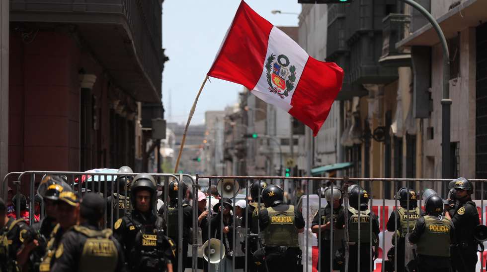 epa12750957 A person holds a Peruvian flag during a demonstration against interim president Jose Jeri in front of the Peruvian Congress in Lima, Peru, 17 February 2026. The Peruvian Congress began a special session to discuss seven motions of censure filed against Jeri, which could lead to the eighth presidential change in the Andean country in nearly a decade of political instability.  EPA/Paolo Aguilar