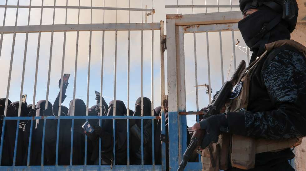 epaselect epa12667349 Members of the Syrian security stand in front of the gate of the Al-Hol camp, which houses families of suspected Islamic State (IS) group fighters, after the Syrian government took control of the area, in Hasakeh province, Syria, 21 January 2026. According to the Syrian Interior Ministry, security forces have entered al-Hol camp in Hasakah province to maintain stability following the withdrawal of Kurdish-led Syrian Democratic Forces (SDF) units and the temporary lack of guard presence.  EPA/MOHAMMED AL-RIFAI