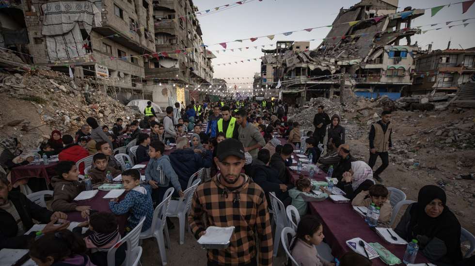 epa12769447 Palestinians gather amid destroyed homes to share the iftar meal together during the holy month of Ramadan in Gaza City, 22 February 2026.  EPA/HAITHAM IMAD