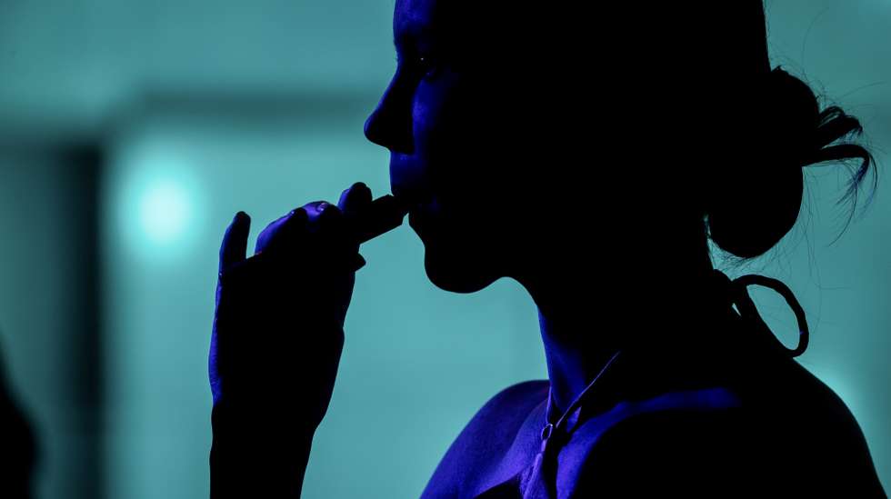 epa10729928 A person inhales a vape at a party in Caracas, Venezuela, 02 July 2023 (issued 06 July 2023). The order of the Venezuelan president Nicolas Maduro to evaluate the possibility of banning the sale of electronic cigarettes aroused the concern of sellers, who defend their use without opposing its regulation, and the expectations of the health sector, which supports the proposal for considering it preventive. The Pan American Health Organization (PAHO) stated that 'electronic cigarettes are the most common form of electronic nicotine delivery systems,' and that they 'threaten to upend decades of the fight against smoking.'  EPA/MIGUEL GUTIERREZ