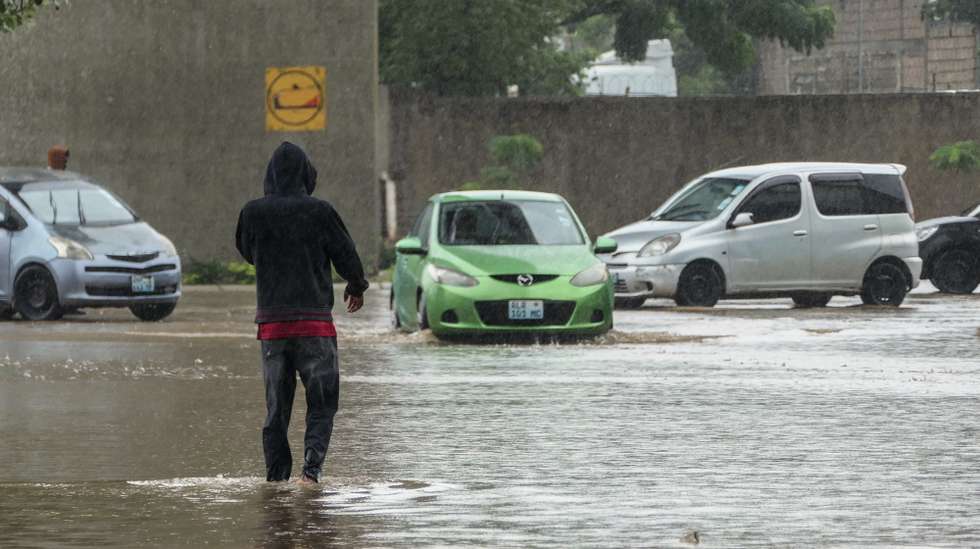 Um popular caminha por uma rua inundada devido às chuvas na cidade de Maputo, Moçambique, 12 de março de 2026. A cidade de Maputo regista desde a manhã de hoje novas cheias, que condicionam a circulação em várias zonas da capital moçambicana, devido às fortes chuvas, pela segunda vez em menos de uma semana. (ACOMPANHA TEXTO). LINA CEBOLA/LUSA