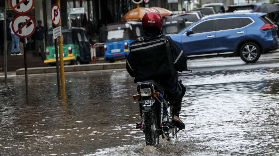 Um motociclista circula por uma rua inundada devido às chuvas na cidade de Maputo, Moçambique, 12 de março de 2026. A cidade de Maputo regista desde a manhã de hoje novas cheias, que condicionam a circulação em várias zonas da capital moçambicana, devido às fortes chuvas, pela segunda vez em menos de uma semana. (ACOMPANHA TEXTO). LINA CEBOLA/LUSA
