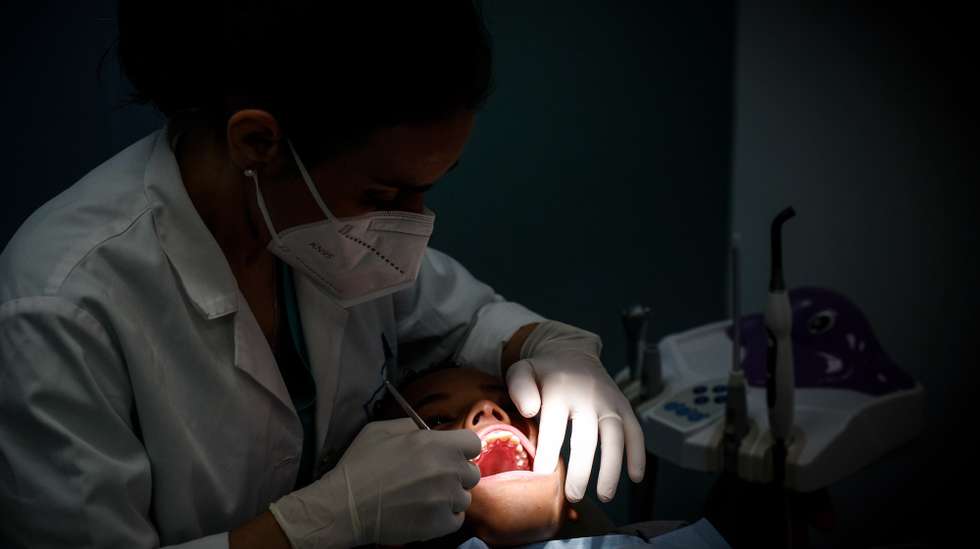 Uma dentista durante um tratamento a um rapaz na clínica “O Sol” que oferece tratamento dentário gratuito a crianças até aos 18 anos, Lisboa, 19 de março de 2025. A 20 de Março comemora-se o Dia Mundial da Saúde Oral.  (ACOMPANHA TEXTO DE 20-03-2025) ANTÓNIO PEDRO SANTOS/LUSA