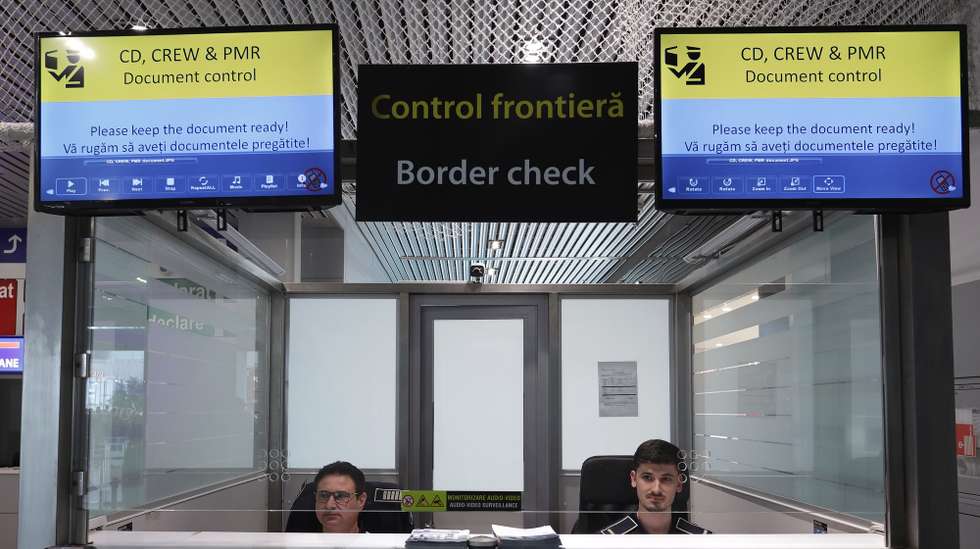 epa12790127 Two Romanian border police officers observe the passengers from their control boot, after a press conference about the EES (Entry/Exit System) final implementation performed by the Romanian Border Police inside the departures terminal at Bucharest Henri Coanda International Airport, in Otopeni city, 20 km north of Bucharest, Romania, 02 March 2026. The ESS system becomes operational from 02 March 2026 at Henri Coanda International Airport, as well as in 21 other border points. The EES system was introduced in stages starting from 12 October 2025. The EES is a modern electronic system that records the date and place of entry and exit of third-country nationals admitted for short stays (maximum 90 days in any 180-day period) in the European Union. The system collects alphanumeric and biometric data (facial image and four fingerprints) and automatically calculates the duration of the authorised stay.  EPA/ROBERT GHEMENT