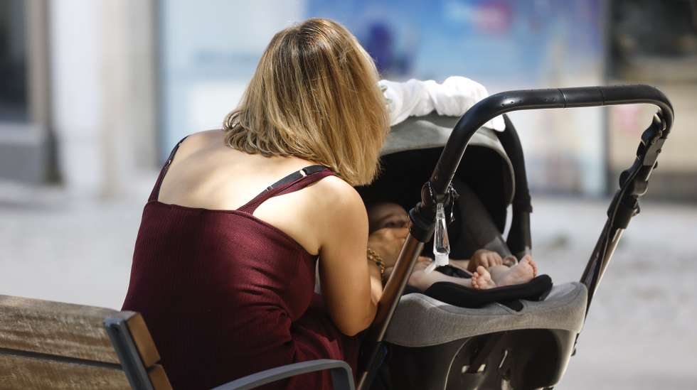 Uma mãe alimenta o seu bebé na Praça de Londres, em Lisboa, 14 de agosto de 2025. Amamentação. Recém-nascido. Crianças. ANTÓNIO PEDRO SANTOS/LUSA