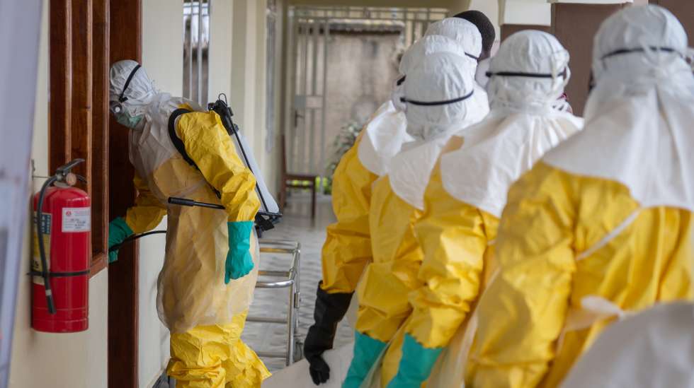 epa12987166 Health workers wearing full personal protective equipment (PPE) prepare to transport the body of an Ebola victim for a safe burial at Sofepadi Hospital in Bunia, Ituri province, Democratic Republic of the Congo, 23 May 2026. The World Health Organization (WHO) recently raised the national risk level of the virus's spread to 'very high' following a surge in cases. The outbreak, officially declared by the DRC Ministry of Health on 15 May, is driven by the Bundibugyo strain of the virus, for which there are currently no approved vaccines or specific therapeutic treatments.  EPA/STRINGER