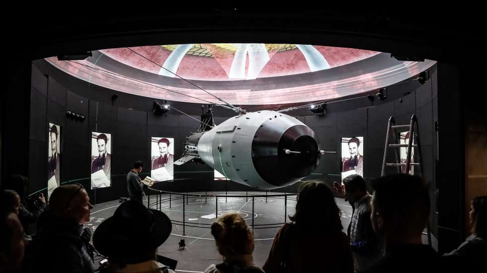 epa10940870 Visitors look at a scale model of the casing of the Tsar Bomba, the most powerful nuclear weapon ever created and tested, during a press tour of the new 'Atom' pavilion dedicated to Rosatom corporation at the All-Russian Exhibition Center (VDNH) in Moscow, Russia, 26 October 2023. The Atom exhibition pavilion is an educational complex with the largest and most modern exhibition in Russia dedicated to  the development of nuclear energy. The total area of the pavilion is 25,000 square meters, and can accommodate more than 2 thousand people at a time. The Atom Pavilion will open on 4 November 2023.  EPA/YURI KOCHETKOV