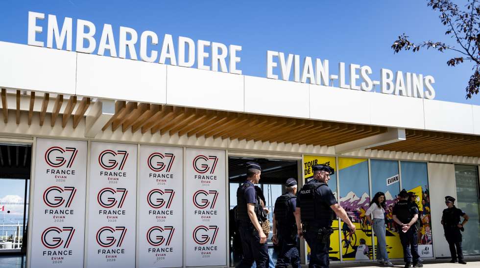 epaselect epa13020181 French police officers walk in front of a G7 banner in Evian-les-Bains, France, 06 June 2026. The 52nd G7 Summit will take place from 15 to 17 June 2026 in Evian-les-Bains. It will bring together the United States, the United Kingdom, Canada, Germany, Italy, Japan, and France. Additionally, the European Union (EU) joins as a 'non-enumerated' member.  EPA/JEAN-CHRISTOPHE BOTT