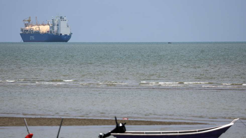 epa12891896 A small boat is seen near the liquefied natural gas (LNG) tanker ETYFA-Prometheas in the Malacca Strait, Malaysia, 15 April 2026. The US has begun restricting vessels entering or leaving Iranian ports in an effort to curb Iran’s energy exports. According to US officials, ships transiting the Gulf or calling at third-country ports such as Saudi Arabia or the UAE are not affected.  EPA/FAZRY ISMAIL
