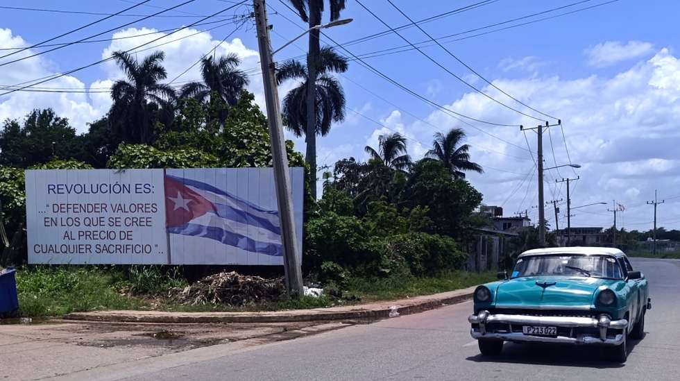 epa13045006 A vehicle drives past a billboard with a slogan reading 'Revolution is: defending values one believes in at the price of any sacrifice', in Havana, Cuba, 16 June 2026 (issued 17 June 2026). Cuban President Miguel Diaz-Canel has unveiled a sweeping package of economic reforms, marking a historic shift away from the island's decades-old, state-centralized model.  EPA/ERNESTO MASTRASCUSA