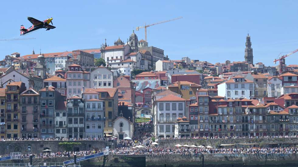 Um avião faz acrobacias durante o festival aéreo Air Invictus, que decorreu no rio Douro entre as margens do Porto e de Vila Nova de Gaia, 20 de junho de 2026. Os primeiros aviões do Air Invictus já abriram as hostilidades no Porto e em Gaia para um “bálsamo desejado” para os comerciantes, um “evento do caraças” para os turistas e um momento “seja o que Deus quiser” para as autoridades. FERNANDO VELUDO/LUSA