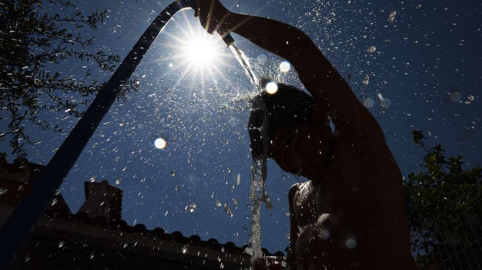 Uma criança refresca-se com uma mangueira quando as temperaturas rondam os 40 graus, Elvas, 1 de julho de 2026. O tempo quente que afeta Portugal dará origem a uma onda de calor que se prolongará por oito a 10 dias e atingirá praticamente todo o país, estimou hoje o Instituto Português do Mar e da Atmosfera (IPMA). NUNO VEIGA/LUSA