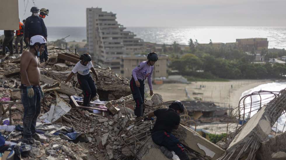 epa13099298 Members of Venezuela's Civil Protection search for victims among the rubble of buildings destroyed by earthquakes in Catia La Mar, La Guaira, Venezuela, 08 July 2026. The death toll from the earthquakes two weeks ago has risen to 3,811, while the number of injured remains at 16,740, according to official figures.  EPA/Miguel Gutierrez