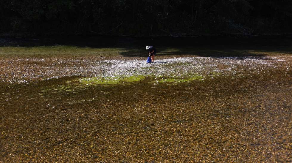 epa13152096 A woman packs her stuff at the Isar River during hot weather in Munich, Germany, 05 August 2026.  EPA/ANNA SZILAGYI