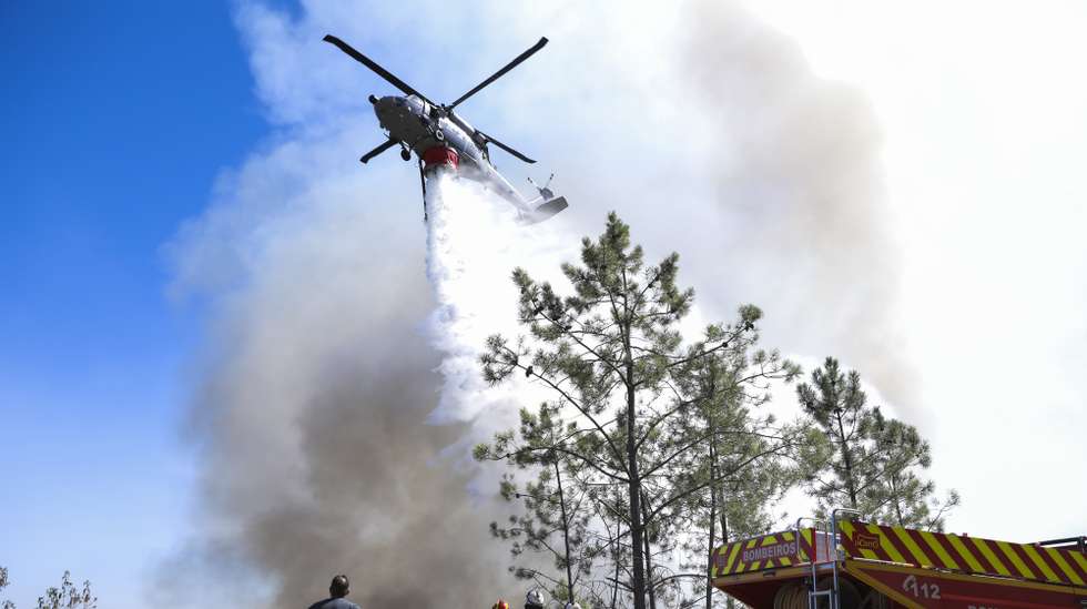 Um helicóptero UH-60 Black Hawk da Força Aérea Portuguesa faz uma descarga de água sobre as chamas durante o combate ao incêndio que lavra em Alvito da Beira, Proença-a-Nova, Castelo Branco, 15 de setembro de 2026. PAULO CUNHA/LUSA