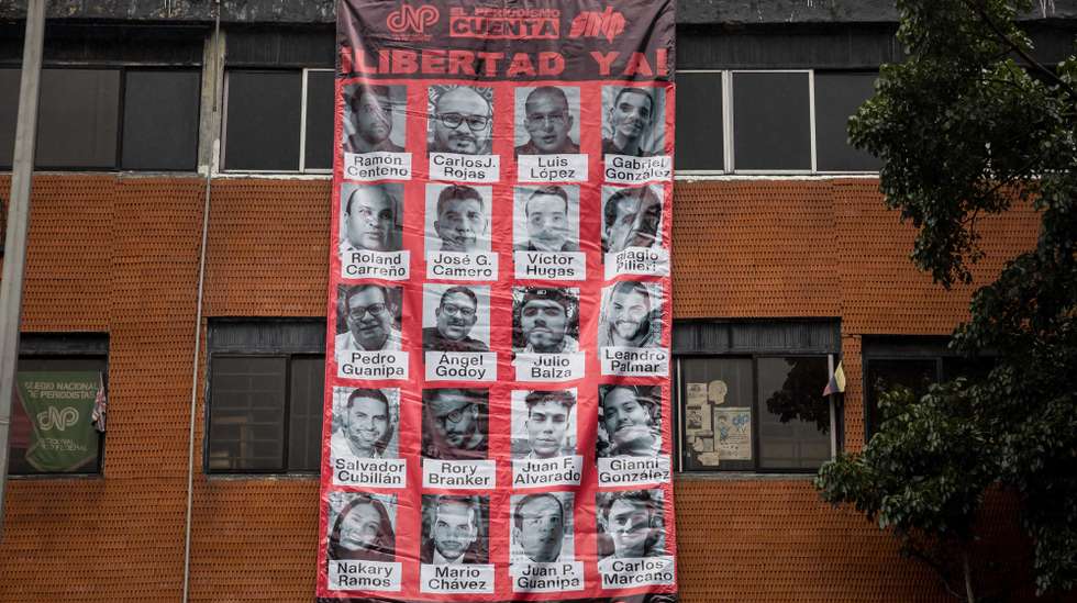 epa12216592 People display a banner showing the images of several journalists imprisoned during a protest in Caracas, Venezuela, 04 July 2025. Organizations, journalists and press workers in Venezuela demanded the release of 20 colleagues detained in the country.  EPA/MIGUEL GUTIERREZi
