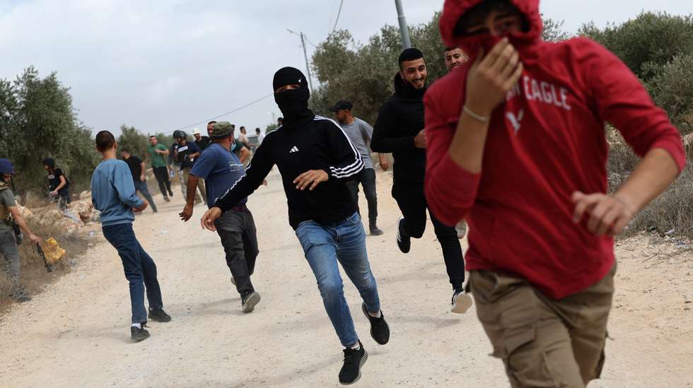 epaselect epa13309134 Palestinians run for cover from tear gas fired by the Israeli army following a settlers' attack on families harvesting their olive trees in Abu Falah, West Bank, 16 October 2026. According to Wafa, several Palestinians and a foreign journalist were injured in Israeli settler attacks on residents and olive pickers up to 3 locations in the central West Bank.  EPA/ATEF SAFADI
