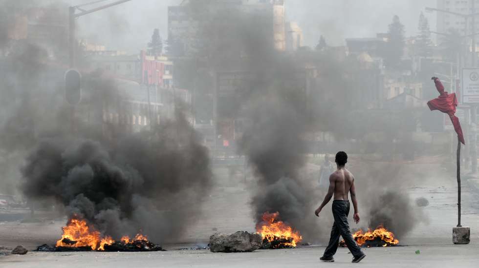 epaselect epa11791179 A man walks next to a burning barricade during a protest after the Constitutional Council proclaimed Daniel Chapo as the winner of the presidential election with 65.17% of the votes, in Maputo, Mozambique, 23 December 2024. Daniel Chapo was proclaimed on 23 December as the fifth President of Mozambique following the elections held in October 2024.  EPA/PAULO JULIAO