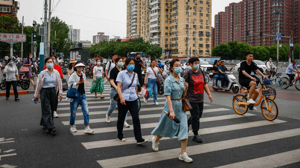 epa10661656 People cross a road in Beijing, China, 29 May 2023. China's new wave of Covid infections could peak by June with an estimated 65 million cases a week, said Zhong Nanshan, director of the National Clinical Research Center for Respiratory Disease on 22 May 2023. The new infections are mostly from the omicron subvariant XBB after China abandoned the 'zero-Covid' policy at the end of the year 2022.  EPA/MARK R. CRISTINO