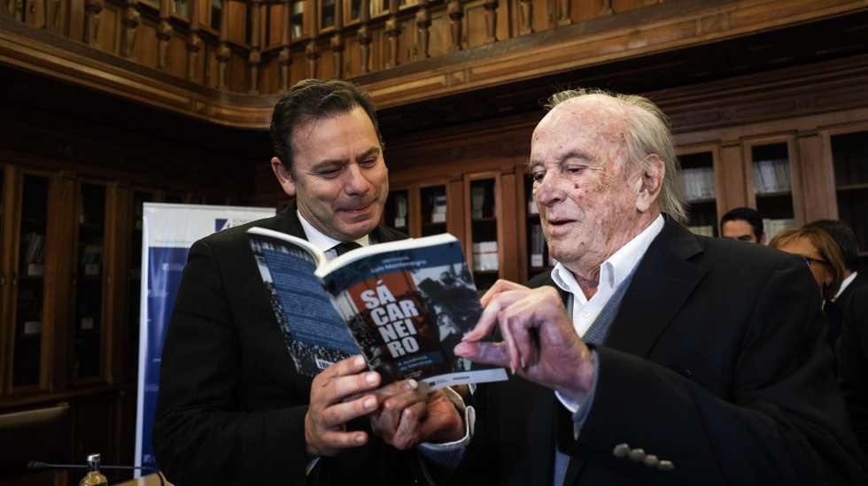 O presidente do Partido Social Democrata (PSD), Luis Montenegro, conversa com um dos fundadores do seu partido, Francisco Pinto Balsemão, na sessão de apresentação do livro: Francisco Sá Carneiro, na Assembleia da República em Lisboa, 02 de março de 2023. TIAGO PETINGA/LUSA