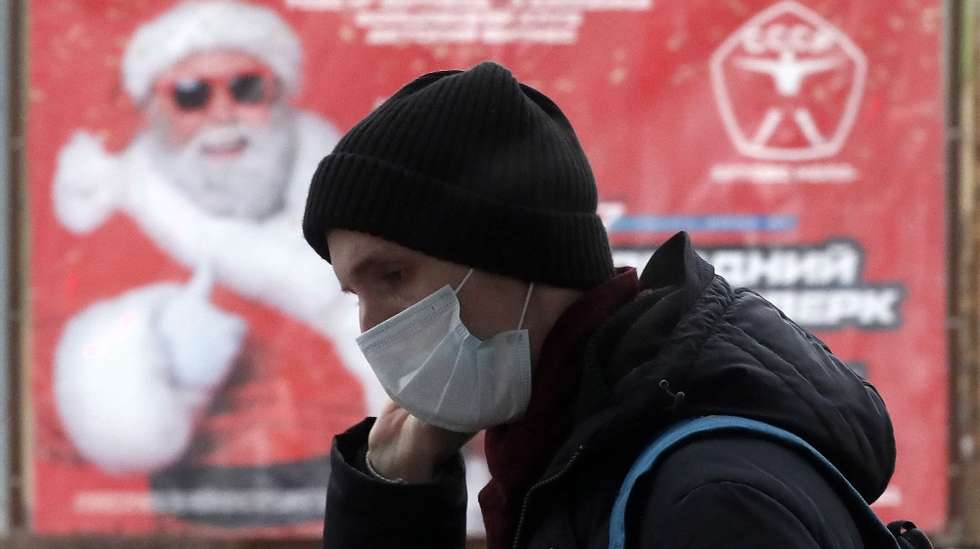 epa08899381 A man wearing a protective face mask walks on a street decorated for the upcoming Christmas and New Year&#039;s celebrations during the pandemic of SARS-CoV-2 coronavirus in Moscow, Russia, 22 December 2020. The Mayor of Moscow Sobyanin signed a decree abolishing New Year and Christmas corporate events and mass celebrations in the city, reports state.  EPA/MAXIM SHIPENKOV