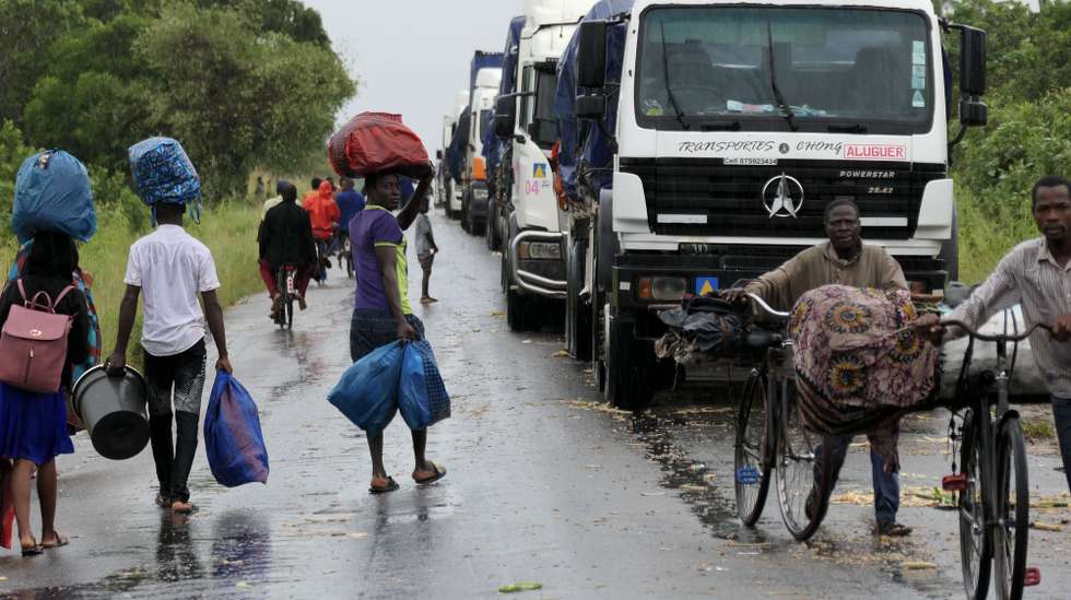 People walk on a road flooded by the storm Freddy, Maputo, Mozambique, 14 March 2023. This is one of the longest lasting storms ever, after it formed at the beginning of February in the Asian seas, crossing the entire Indian Ocean to the east African coast. Until now 10 people have been killed by the storm accordind to official data. ANDRE CATUEIRA/LUSA