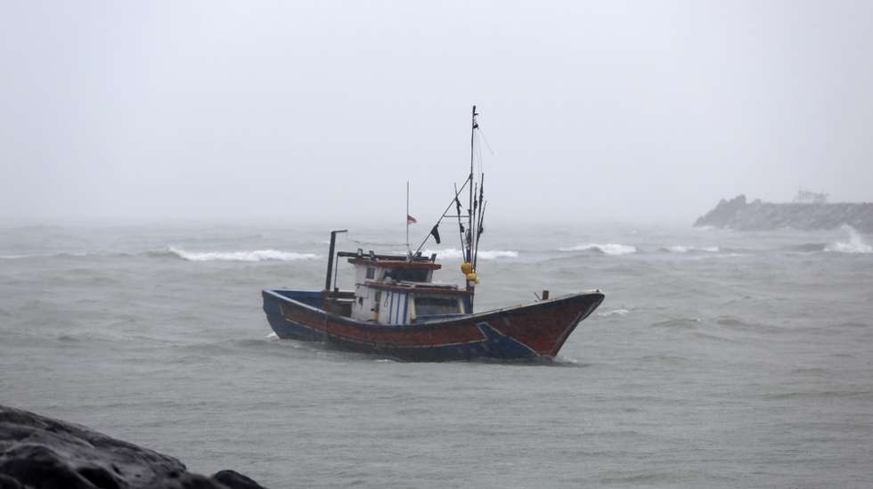epa12236789 Fishermen endure rain while sailing home from fishing amidst a severe weather warning, in Banda Aceh, Indonesia, 14 July 2025. The Meteorology, Climatology, and Geophysics Agency (BMKG) Aceh Meteorology Station issued an early warning regarding rain, strong winds and lightning accompanied by thunder throughout the Aceh region.  EPA/HOTLI SIMANJUNTAK