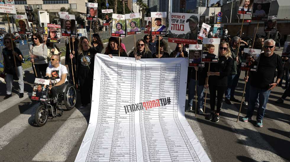 epa11810891 Families and supporters of hostages held by Hamas in Gaza display a banner listing the names of the hostages during a protest calling for a ceasefire and for their release outside the Kirya military base in Tel Aviv, Israel, 07 January 2025. According to the Israeli army, around 100 hostages remain in captivity in the Gaza Strip,  including bodies of 33 confirmed dead.  EPA/ABIR SULTAN