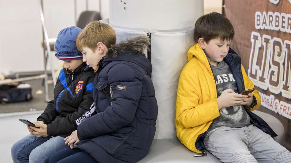 epa07411446 Children are watching their mobile phones while are waiting their mothers, during the professional exhibition 'Beauty 2019' held at the MoldExpo International Exhibition Centre in Chisinau, Moldova, 03 March 2019.  EPA/DUMITRU DORU