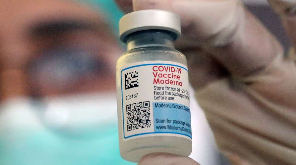 epa10102376 An Indonesian health worker displays a Moderna vaccine vial before administering a dose to her coworkers during a COVID-19 booster vaccination drive in Jakarta, Indonesia, 02 August 2022. The Indonesian government started the fourth booster dose of COVID-19 vaccines for health workers amid concerns on the spread of a new COVID-19 variant.  EPA/Bagus Indahono