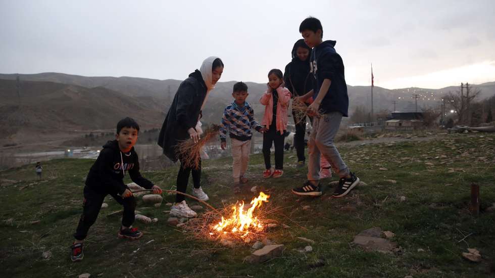 epa09827262 Afghan refugees children gather around a fire during a traditional fire feasts (Charshanbeh Suri) in Lavasan, Iran, 15 March 2022. The festival is held annually on the last Wednesday eve before the Persian New Year (Nowruz), which starts on 21 March, also marking the beginning of spring. Nowruz, which has been celebrated for at least three thousand years, is the most revered celebration in the greater Persian world, which includes the countries of Iran, Afghanistan, Azerbaijan, Turkey, and portions of western China and northern Iraq.  EPA/ABEDIN TAHERKENAREH