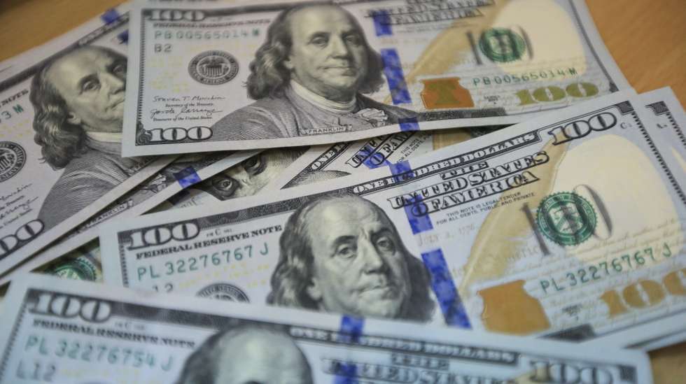 epa10210339 US dollar banknotes are displayed on a table at a money exchange company in Nairobi, Kenya, 27 September 2022. A worker points at the Euro currency exchange rate against the Kenyan shilling on a currency board at a money exchange company in Nairobi, Kenya, 27 September 2022.  EPA/Daniel Irungu