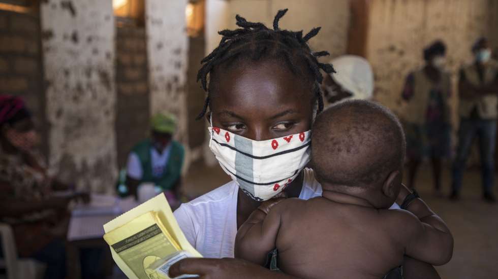 Mãe e filho aguardam pela consulta de uma brigada móvel do Fundo das Nações Unidas para a Infância (UNICEF), um grupo de profissionais de saúde que viaja de ambulância e vai ao encontro das comunidades mais afastadas em vez de esperar por elas em centros de saúde, Impire, Moçambique, 24 de julho de 2020. Em menos de uma hora, na povoação de Impire, distrito de Metuge, sul de Cabo Delgado, juntam-se dezenas de mães com as suas crianças - a maioria ainda bebés - para a brigada observar, com pesagem, medição de altura, avaliação à subnutrição, seguindo-se uma consulta, vacinação e entrega da medicamentos numa rotina que inclui a observação das mães e decorre desde manhã até o sol se pôr, num pavilhão empoeirado. (ACOMPANHA TEXTO DE 25 DE JULHO DE 2020). RICARDO FRANCO/LUSA