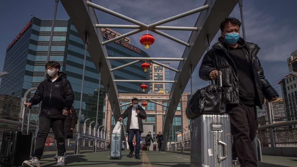 epaselect epa09000277 Chinese passengers carry their luggage and walk on a bridge towards the Beijing Railway Station before the upcoming Chinese Lunar New Year, in Beijing, China, 10 February 2021. The Lunar New Year, also known as Spring Festival, falls on 12 February 2021, marking the beginning of the Year of the Ox. Authorities in China urged people not to travel to their hometowns during Lunar New Year due to the COVID-19 outbreaks in the country.  EPA/ROMAN PILIPEY