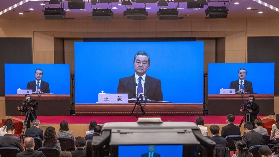 epa09058456 Chinese Foreign Minister Wang Yi is seen on a screen as he speaks to reporters during an online press conference, in Beijing, China, 07 March 2021. China holds two major annual political meetings, The National People’s Congress (NPC) and the Chinese People's Political Consultative Conference (CPPCC) which run alongside and together known as 'Lianghui' or 'Two Sessions'.  EPA/ROMAN PILIPEY