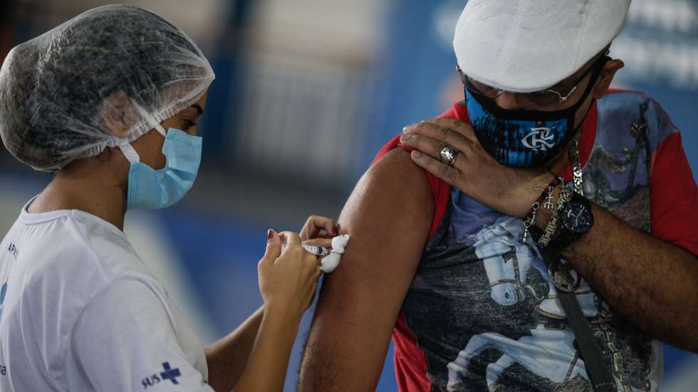 epa09148193 A man receives the dose of the Astrazeneca vaccine against covid-19, in the block of Portela, one of the most traditional carnival groups in Rio de Janeiro, Brazil, 20 April 2021. Brazil is the second country with the most deaths, behind the United States, although it is currently the place on the planet where most people die from covid-19. In terms of infections, the South American power is located in third place, after the US and India.  EPA/Andre Coelho