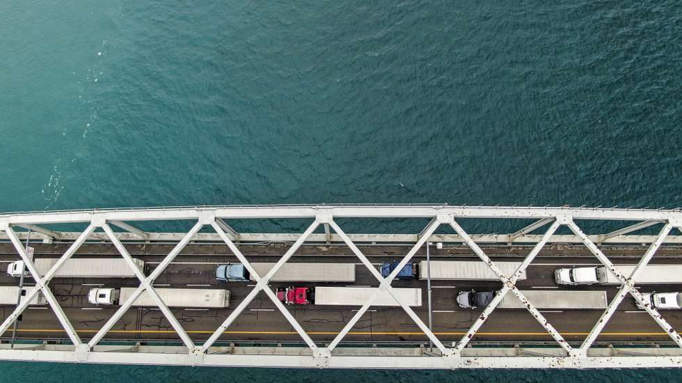 epa09747773 An aerial photo made with a drone shows trucks backed up on the Blue Water Bridge over the St. Clair River that links the US and Canada between Port Edward, Ontario, Canada and Port Huron, Michigan, USA, 11 February 2022. Canadian truckers protesting the vaccine mandate have shut down the Ambassador Bridge at Detroit, Michigan, USA, a vital link where 25 percent of goods between the two countries passes, forcing vehicles to re-route over the Blue Water Bridge.  EPA/TANNEN MAURY