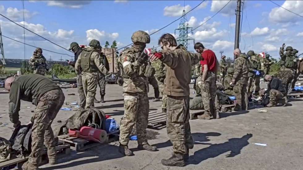epa09962236 A still image taken from handout video made available on 21 May 2022 by the Russian Defence Ministry's press service shows Russian servicemen frisking Ukrainian servicemen evacuated from the besieged Azovstal steel plant in Mariupol, Ukraine, 20 May 2022 (issued 21 May 2022). The Chief spokesman of the Russian Defense Ministry, Major General Igor Konashenkov, said on 20 May that the Azofstal steel plant is now under full Russian army control. Russian troops entered Ukraine on 24 February 2022.  EPA/RUSSIAN DEFENCE MINISTRY PRESS SERVICE/HANDOUT BEST QUALITY AVAILABLE HANDOUT EDITORIAL USE ONLY/NO SALES