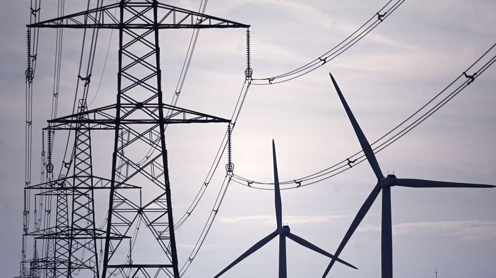 epa09884956 Wind Turbines and electricity pylons on a wind farm at Little Cheyne Court in Romney, in southern Britain, 11 April 2022. Wholesale energy prices have risen, with the average UK family's energy bills rising by up to 54 percent. The UK government has published the 'Energy Security Strategy' to help tackle soaring energy prices and reduce reliance on Russian oil and gas. The plan include investment in nuclear, wind, solar and hydrogen with the government targeting 95 percent of electricity being low carbon by 2030.  EPA/NEIL HALL