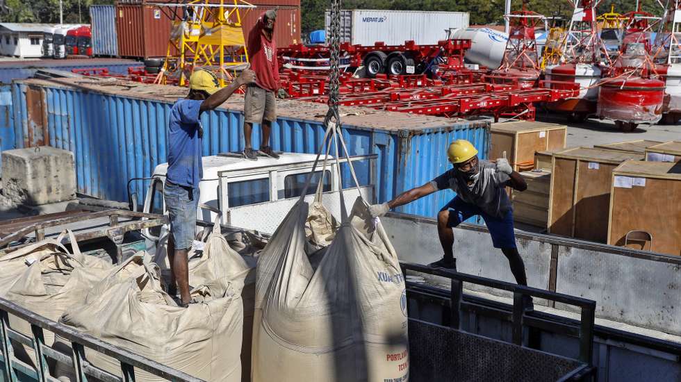 epa10105184 Labourers unload sacks of cement from a cargo ship onto a truck at a port in Dili, East Timor, also known as Timor Leste, 04 August 2022. According to Asian Development Bank (ADP) Timor Leste's gross domestic product (GDP) expected to grow 2.5 percent in 2022 and 3.1 percent in 2023.  EPA/ANTONIO DASIPARU