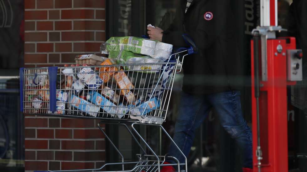 epa08294032 A man leaves a supermarket with a shopping cart full of goods in Berlin, Germany, 14 March 2020.  EPA/HAYOUNG JEON