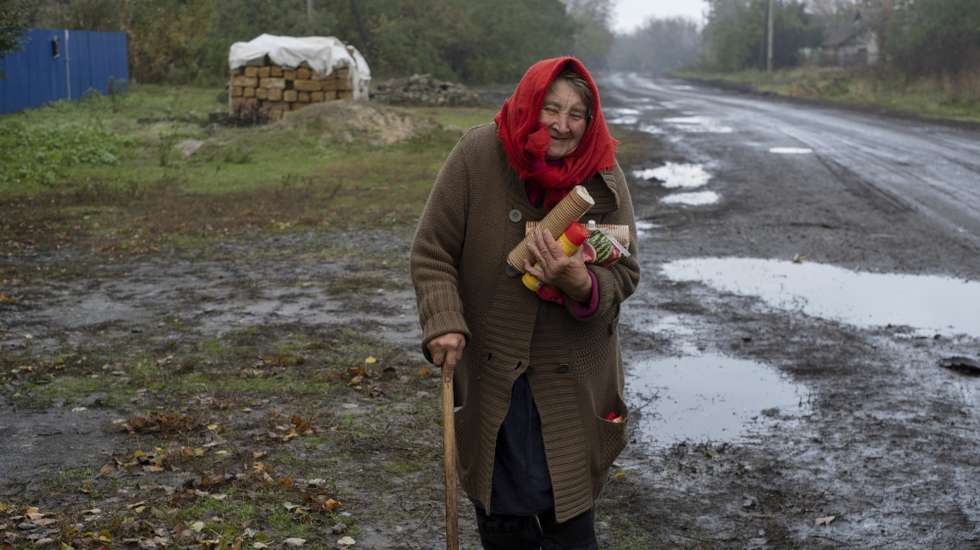 epa10255859 An elderly woman carries food after she received humanitarian aid in a recently liberated part of Kharkiv's area, Ukraine, 20 October 2022. The Ukrainian army pushed Russian troops from occupied territory in the northeast of the country in counterattacks. Kharkiv and surrounding areas have been the target of heavy shelling since February 2022, when Russian troops entered Ukraine starting a conflict that has provoked destruction and a humanitarian crisis.  EPA/GEORGE IVANCHENKO