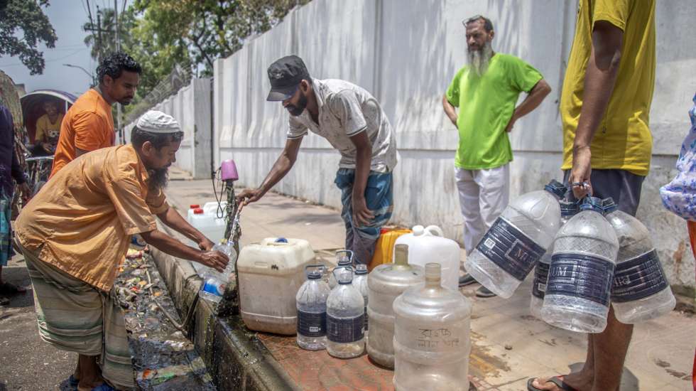 epa11293417 People collect drinking water from the road side water tap during the heatwave in Dhaka, Bangladesh, 22 April 2024. According to the Bangladesh Meteorological Department (BMD) the duration of heat wave has been extended by three more days, Meteorological office issued a new waring on 22 April for next 72 hours.  EPA/MONIRUL ALAM