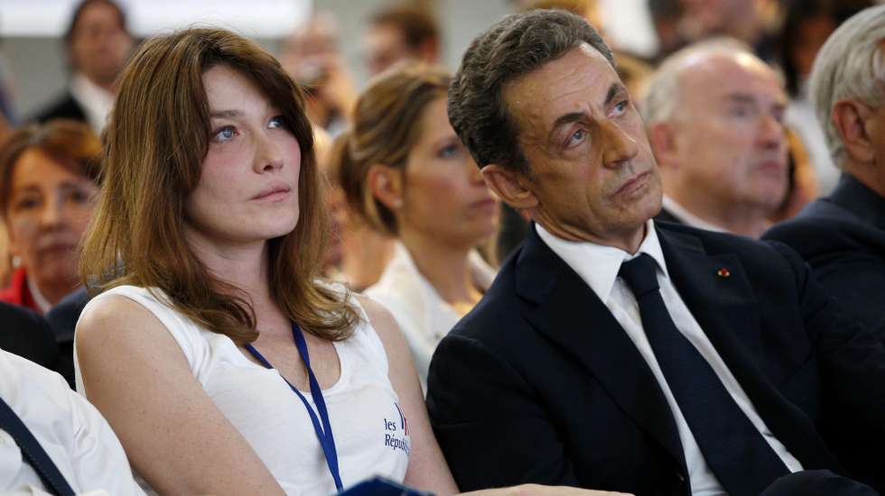 epa04775831 Former French President Nicolas Sarkozy (R) sits with his wife Carla Bruni Sarkozy (L) during the first congress of the new conservative party 'Les Republicains', in Paris, France, 30 May 2015. A French court dismissed objections Tuesday to a proposed name change for one of the country's leading political parties, clearing the way for Sarkozy's Union for a Popular Movement (UMP) to become The Republicans.  EPA/YOAN VALAT