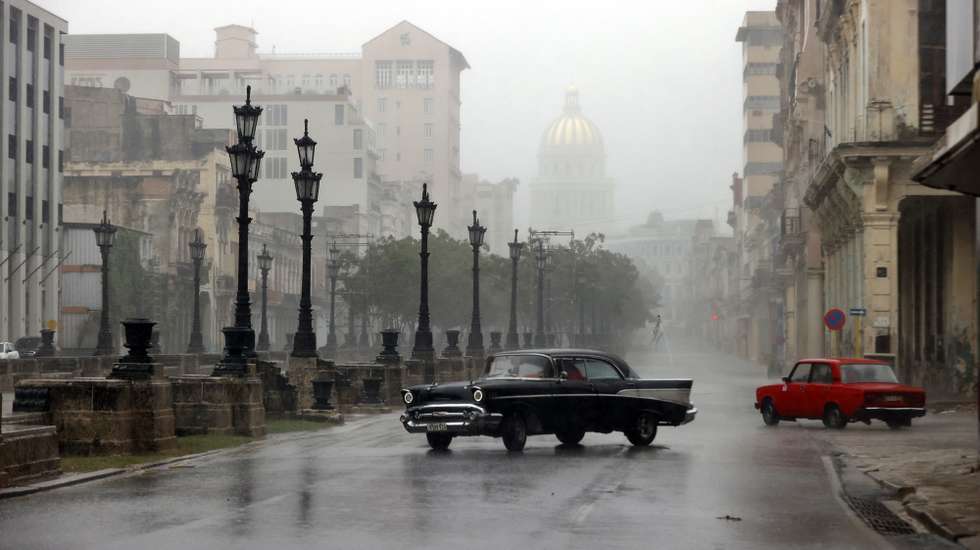 epa11706405 Cars travel along a street during heavy rains caused by the passage of hurricane Rafael, in Havana, Cuba, 6 November 2024. The eye of hurricane Rafael, a category 3 with maximum sustained winds of 185 kilometers per hour (115 miles), made landfall on the southwest coast of Cuba in the province of Artem-isa, in the middle of a massive blackout on the island, the U.S. National Hurricane Center (NHC) reported.  EPA/ERNESTO MASTRASCUSA