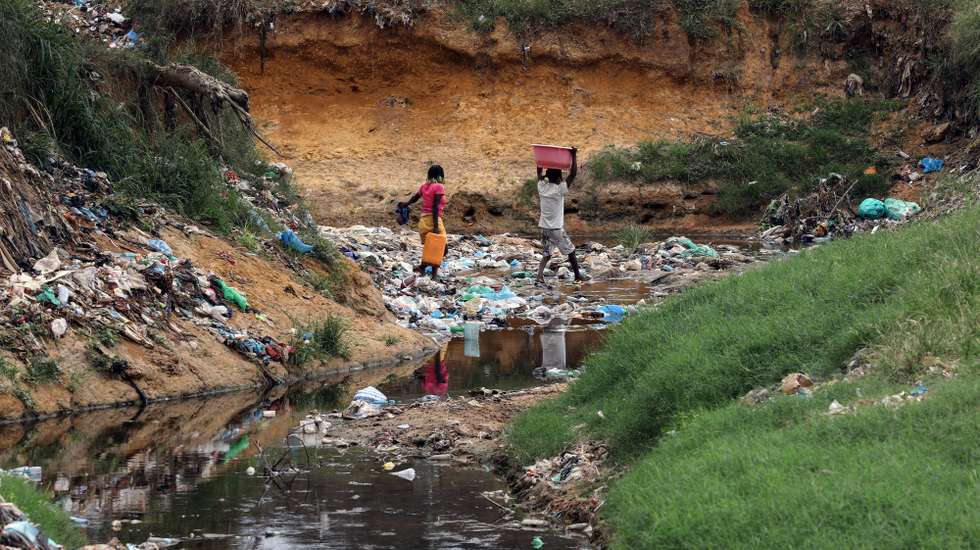 Habitantes atravessam uma enorme vala onde se acumulam detritos e águas paradas no Bairro Paraíso, conhecido pelos níveis elevados de pobreza e criminalidade, a doença e a morte vieram afligir ainda mais os moradores, em Luanda, 09 de janeiro de 2025. Pelo menos cinco pessoas foram oficialmente proclamadas vítimas de cólera, doença ligada à contaminação fecal associada à falta de saneamento e tratamento de água e má higiene, e os habitantes estão preocupados pedindo a intervenção das autoridades angolanas. (ACOMPANHA TEXTO DA LUSA DO DIA 12 DE JANEIRO DE 2025). AMPE ROGÉRIO/LUSA