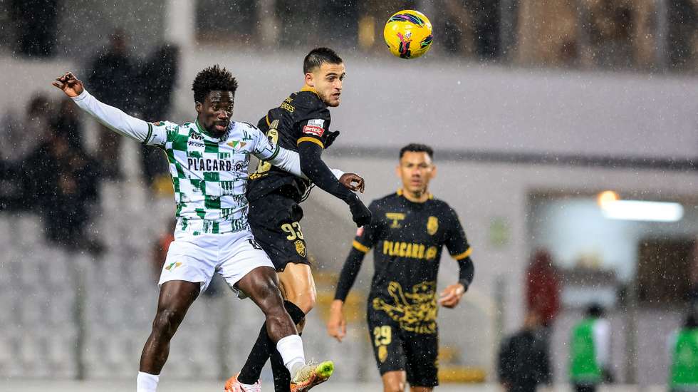 O jogador do Farense, Menino (D), disputa a bola com o jogador do Moreirense, Lawrence Ofori, durante o jogo da 18ª jornada da I Liga de Futebol realizado no Estádio Parque Desportivo Comendador Joaquim de Almeida Freitas, Moreira de Cónegos, 19 de janeiro de 2025. JOSÉ COELHO/LUSA