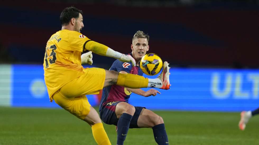 epa11903754 FC Barcelona's Dani Olmo (R) and Rayo Vallecano's goalkeeper Augusto Batalla (L) in action during the Spanish LaLiga soccer match between FC Barcelona and Rayo Vallecano, in Barcelona, Spain, 17 February 2025.  EPA/Alejandro Garcia