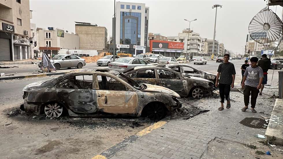 epa12099537 Damaged cars pictured in the street after clashes in Tripoli, Libya, 14 May 2025. Flights at Mitiga Airport were suspended due to clashes while the Ministry of Education had suspended classes in schools in the capital.  EPA/STRINGER